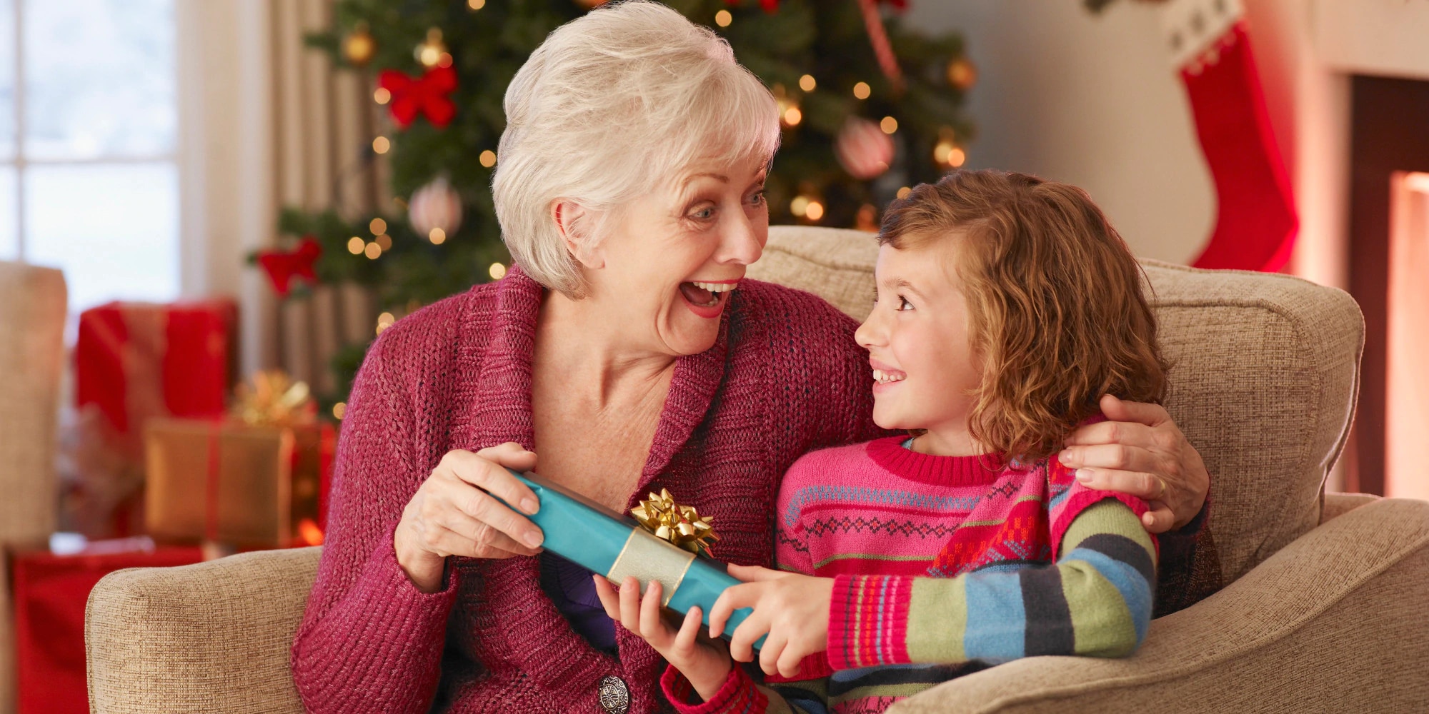 Girl giving grandmother Christmas gift